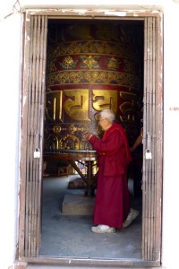 Monk spinning a massive prayer wheel in Boudha